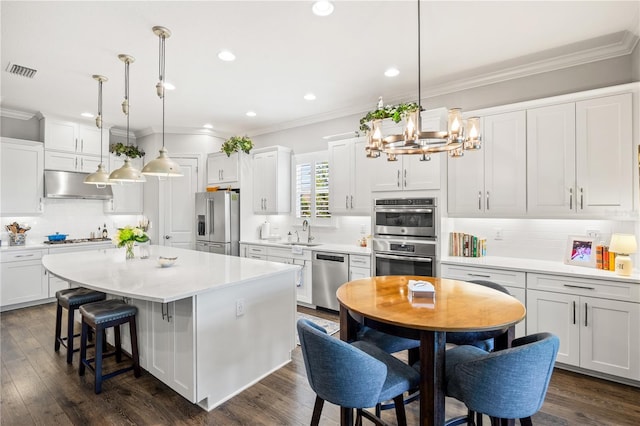 kitchen featuring decorative backsplash, visible vents, appliances with stainless steel finishes, a sink, and under cabinet range hood