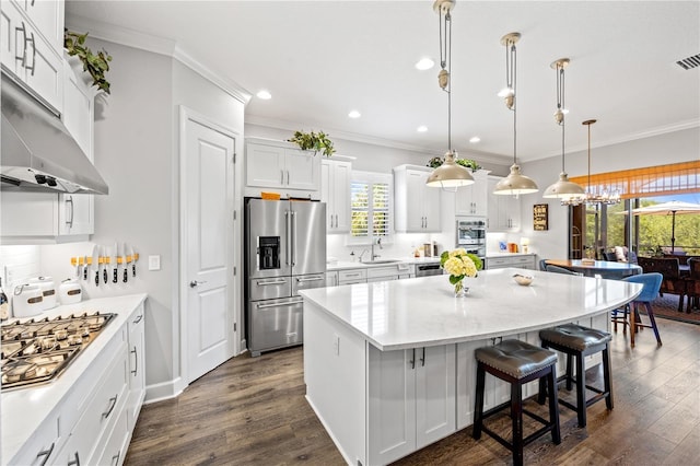 kitchen featuring crown molding, a center island, recessed lighting, a sink, and stainless steel appliances