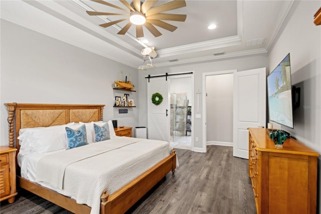 bedroom featuring visible vents, ornamental molding, dark wood-style flooring, a barn door, and a tray ceiling