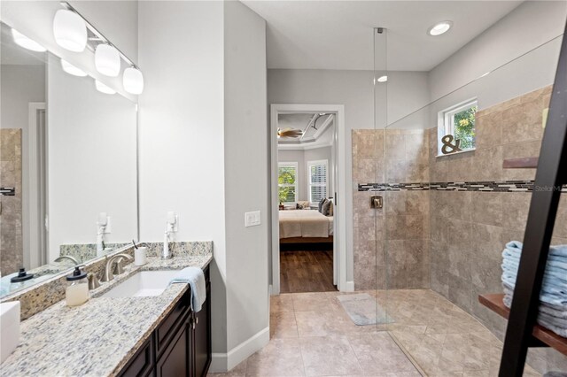 ensuite bathroom featuring a walk in shower, ensuite bathroom, baseboards, and a wealth of natural light