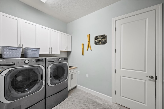 laundry room featuring independent washer and dryer, a textured ceiling, baseboards, and cabinet space