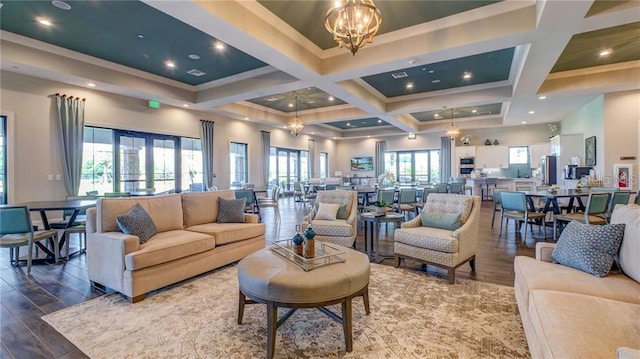 living room with beamed ceiling, a chandelier, wood finished floors, and coffered ceiling