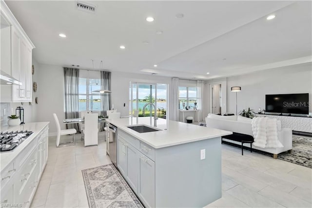 kitchen with a sink, appliances with stainless steel finishes, visible vents, light countertops, and open floor plan