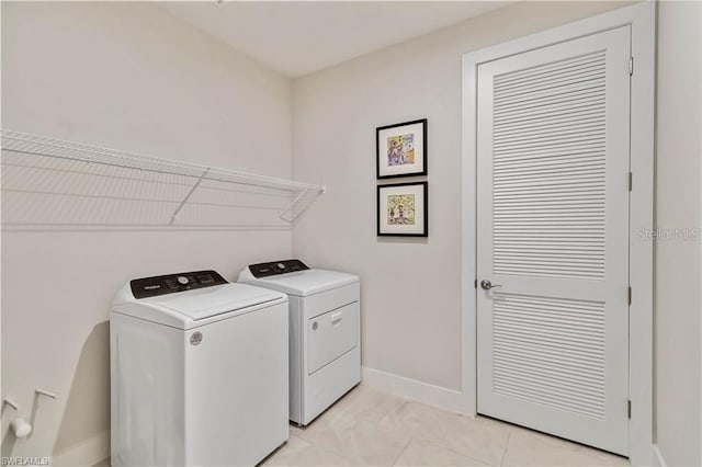 laundry area with baseboards, separate washer and dryer, and laundry area