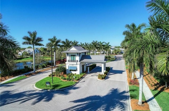 12291 Myrtle Bay Ct, Sarasota, FL 34238 - view of front of home featuring driveway, a standing seam roof, a metal roof, a carport, and a water view