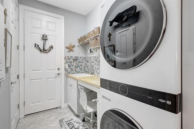 12291 Myrtle Bay Ct, Sarasota, FL 34238 - washroom featuring stacked washer / drying machine, cabinet space, and light marble finish flooring