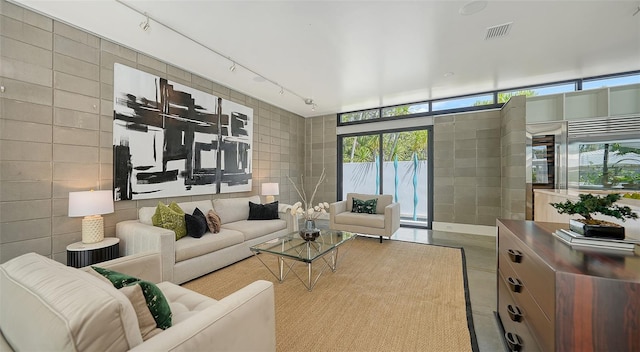 living area with rail lighting, visible vents, and tile walls