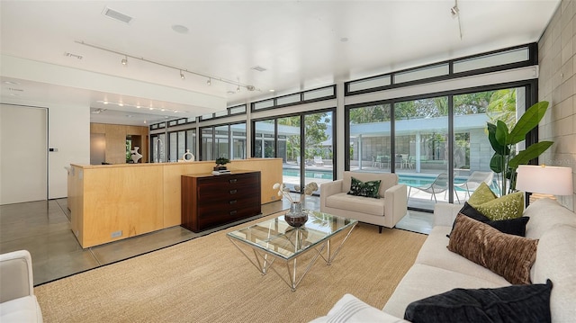 interior space with rail lighting, concrete floors, and visible vents