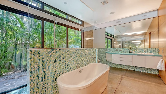 full bath featuring visible vents, a shower with door, a freestanding tub, vanity, and tile patterned flooring