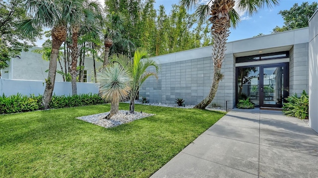 exterior space featuring fence, french doors, and a yard
