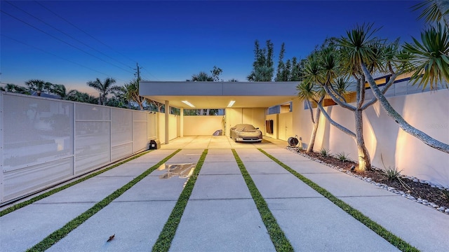 view of patio / terrace with fence, a carport, and concrete driveway