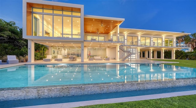 4123 Bay Shore Rd, Sarasota, FL 34234 - back of house at night with ceiling fan, an outdoor hangout area, stairway, a balcony, and a patio
