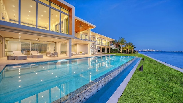 4123 Bay Shore Rd, Sarasota, FL 34234 - pool at night with an outdoor living space, stairs, an infinity pool, a yard, and ceiling fan