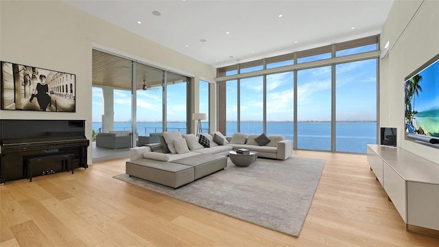 4123 Bay Shore Rd, Sarasota, FL 34234 - living room with a water view, light wood-style flooring, floor to ceiling windows, and a towering ceiling