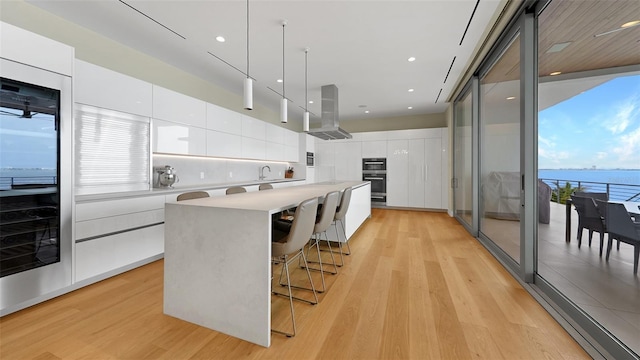 4123 Bay Shore Rd, Sarasota, FL 34234 - kitchen featuring modern cabinets, island exhaust hood, light wood-style floors, light countertops, and recessed lighting