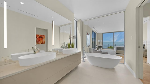 4123 Bay Shore Rd, Sarasota, FL 34234 - bathroom with double vanity, a freestanding bath, tile patterned flooring, expansive windows, and recessed lighting