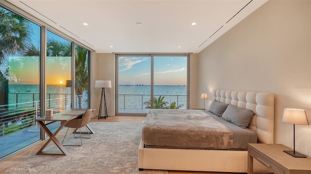 4123 Bay Shore Rd, Sarasota, FL 34234 - bedroom featuring a wall of windows, access to exterior, a water view, light wood-type flooring, and recessed lighting