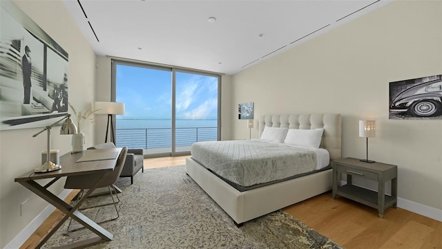 4123 Bay Shore Rd, Sarasota, FL 34234 - bedroom with wood finished floors, access to outside, a wall of windows, baseboards, and a water view