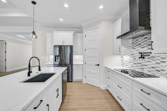 kitchen featuring stainless steel appliances, a sink, white cabinets, and wall chimney range hood