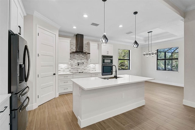 kitchen featuring double oven, a sink, baseboards, wall chimney exhaust hood, and stainless steel fridge