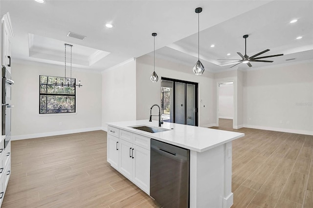 kitchen featuring a sink, stainless steel appliances, light wood-style floors, a tray ceiling, and visible vents