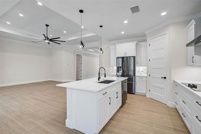 kitchen with crown molding, a sink, appliances with stainless steel finishes, visible vents, and backsplash
