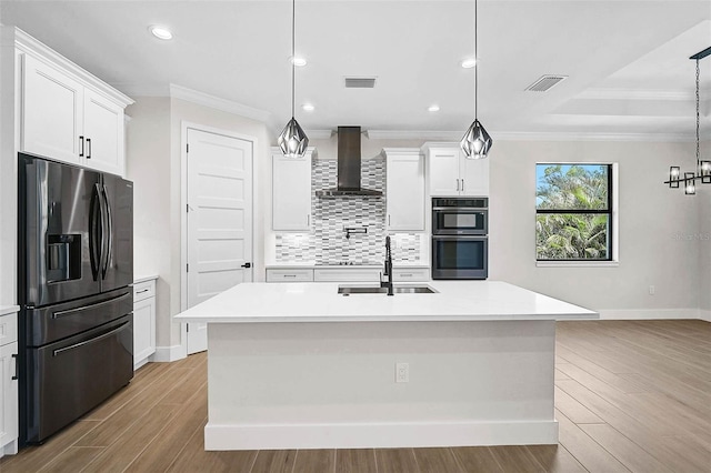 kitchen with double oven, fridge with ice dispenser, a sink, visible vents, and wall chimney exhaust hood