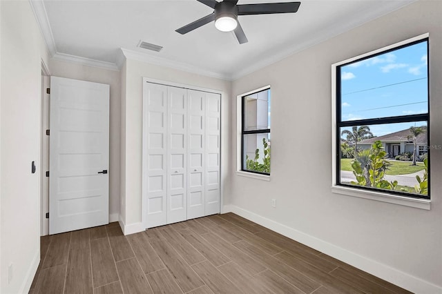 unfurnished bedroom featuring wood finished floors, a closet, and baseboards