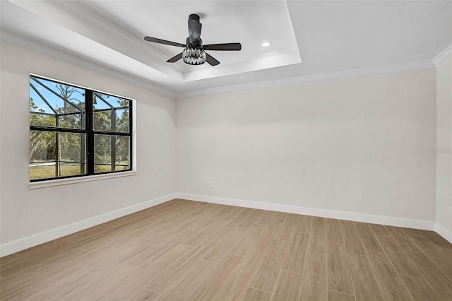 unfurnished room featuring crown molding, a raised ceiling, baseboards, recessed lighting, and light wood finished floors