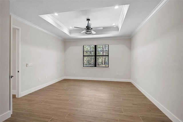 empty room featuring recessed lighting, a raised ceiling, crown molding, a ceiling fan, and wood finished floors