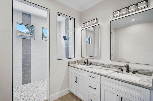 bathroom featuring a walk in shower, wood finished floors, double vanity, and a sink