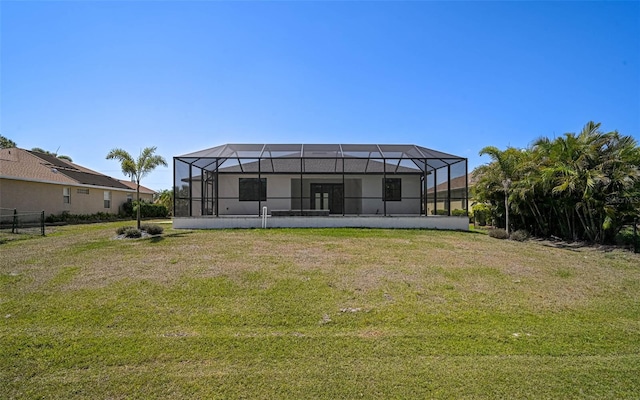 back of house featuring a yard and glass enclosure