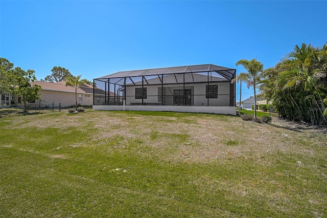 back of house with a lawn and glass enclosure