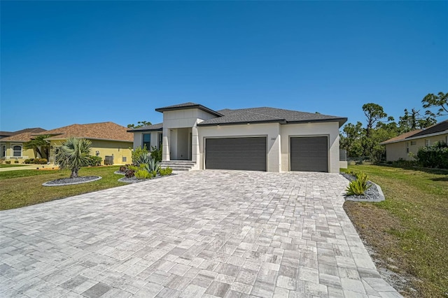 prairie-style house with stucco siding, a front lawn, decorative driveway, and an attached garage