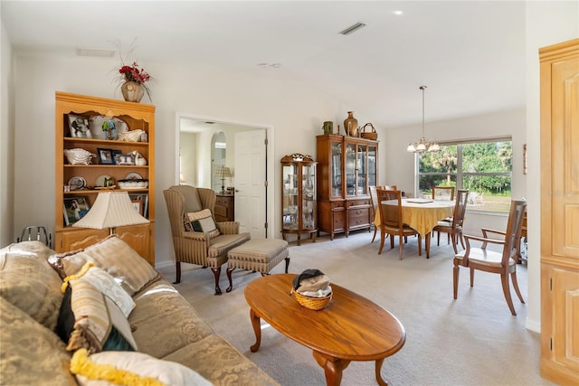 living room with visible vents, a notable chandelier, light carpet, and lofted ceiling