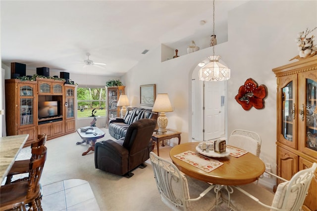 living room with arched walkways, light carpet, ceiling fan, visible vents, and high vaulted ceiling