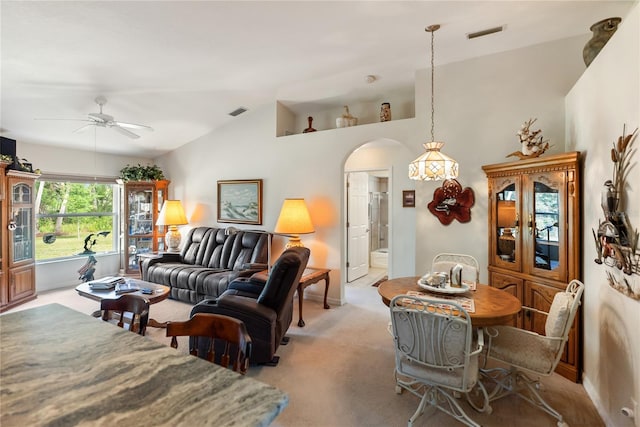 living room with lofted ceiling, a ceiling fan, arched walkways, and light carpet