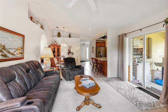 living area with light colored carpet, a ceiling fan, and lofted ceiling