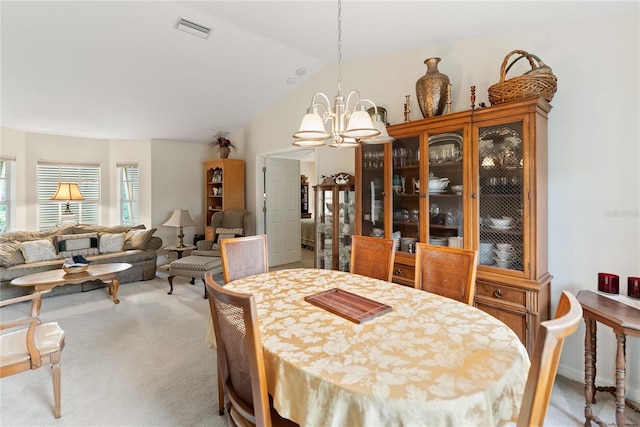 dining area featuring carpet flooring, visible vents, vaulted ceiling, and a chandelier