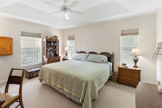 bedroom featuring light colored carpet, a ceiling fan, and baseboards