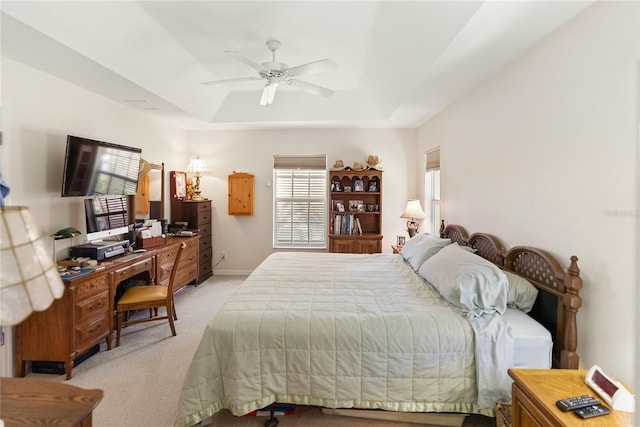 bedroom featuring baseboards, a raised ceiling, ceiling fan, and light colored carpet