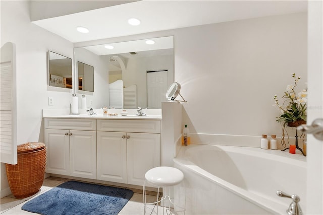 bathroom featuring recessed lighting, a sink, double vanity, a garden tub, and tile patterned flooring