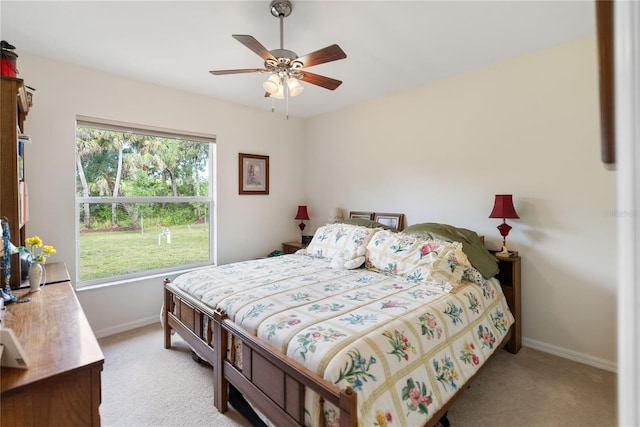 bedroom featuring ceiling fan, baseboards, and light carpet