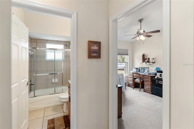 full bathroom with bath / shower combo with glass door, toilet, a ceiling fan, tile patterned flooring, and ensuite bathroom