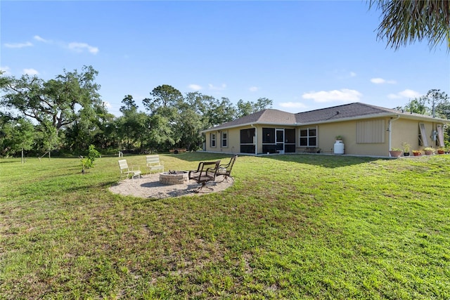 view of yard featuring a fire pit and a sunroom