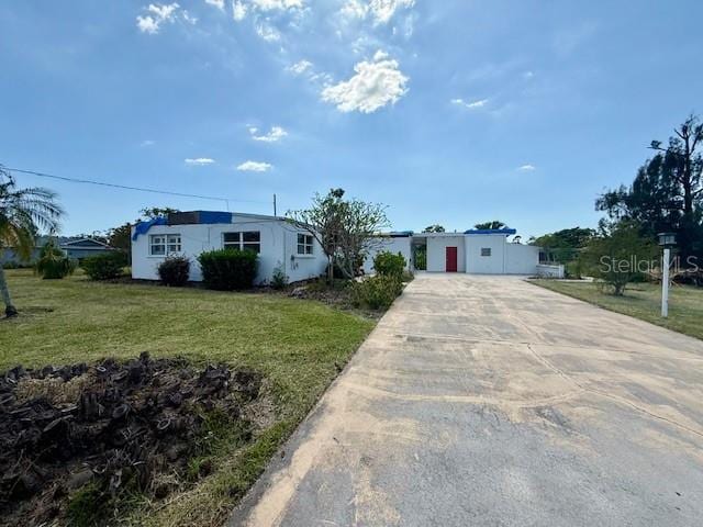 view of front of house with a front lawn, driveway, and stucco siding