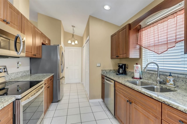 3640 Gloxinia Dr, North Fort Myers, FL 33917 - kitchen with light stone countertops, brown cabinetry, light tile patterned floors, stainless steel appliances, and a sink