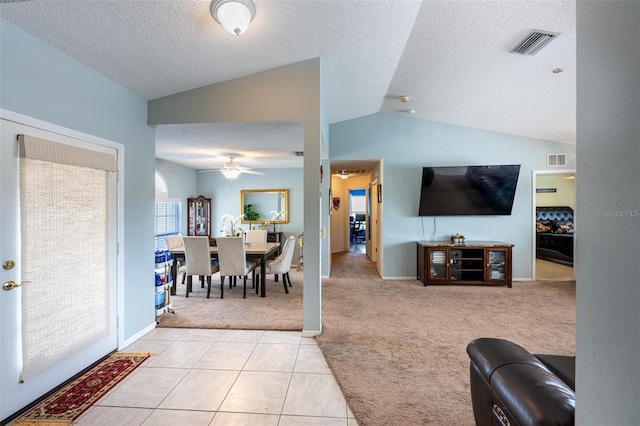 12026 Warwick Cir, Parrish, FL 34219 - living area featuring ceiling fan, light colored carpet, a textured ceiling, vaulted ceiling, and light tile patterned flooring