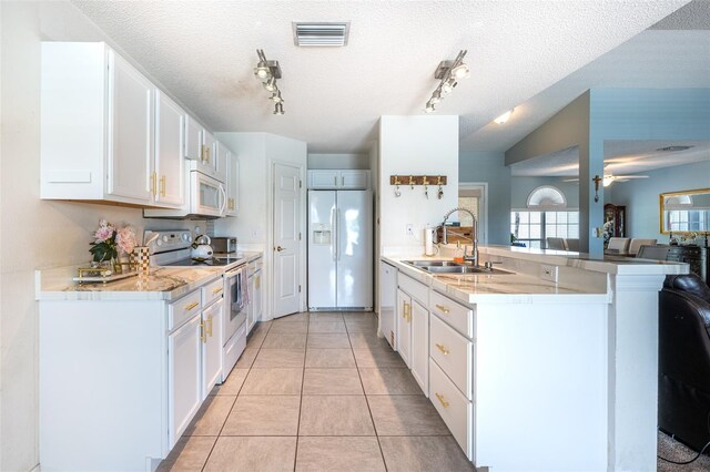 12026 Warwick Cir, Parrish, FL 34219 - kitchen with white appliances, white cabinetry, light countertops, ceiling fan, and a textured ceiling