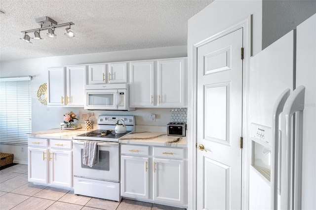 12026 Warwick Cir, Parrish, FL 34219 - kitchen with white appliances, a textured ceiling, white cabinets, and light tile patterned flooring